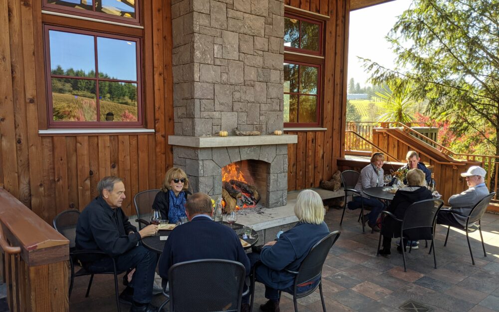 Lemelson Vineyards patio with fireplace, people enjoying wine at two different tables